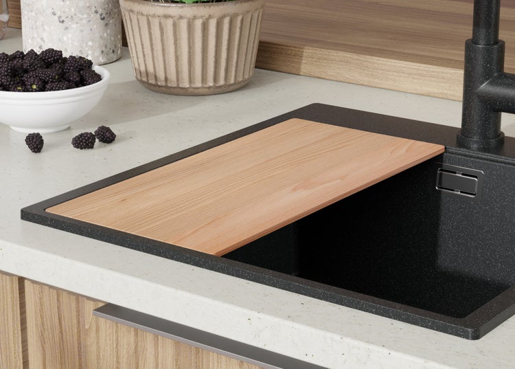 Küchenspüle mit Schneidebrett und Schale mit Brombeeren auf der Arbeitsfläche
