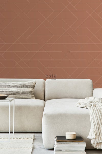 Wohnraum mit geometrischer Mustertapete, Sofa und Wohnaccessoires