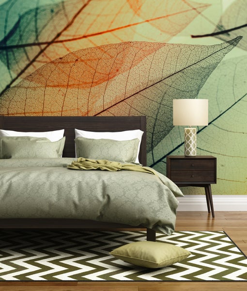 Fototapete mit filigranem Blättermotiv in einem Schlafzimmer mit dunklem Holzbett, passendem Nachttisch und gemustertem Teppich.