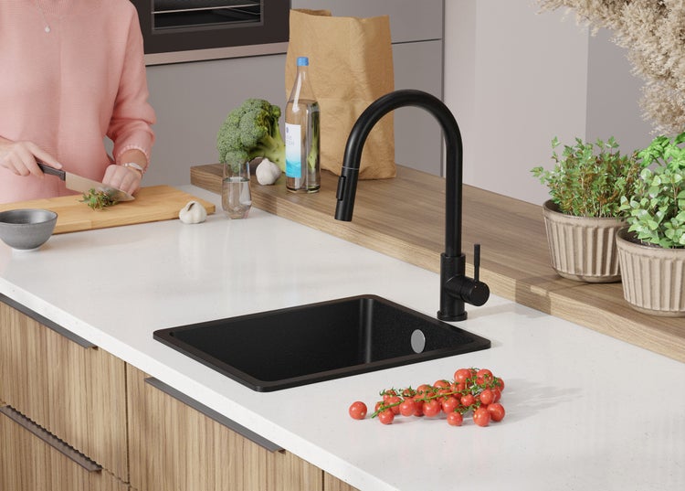 Schwarzes Küchenspülbecken mit Armatur in einer hellen Küche.
