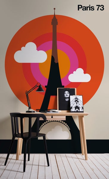 Vliestapete mit Eiffelturm-Silhouette und konzentrischen Kreisen hinter einem Schreibtisch aus Holz mit schwarzem Stuhl und Schreibtischlampe.