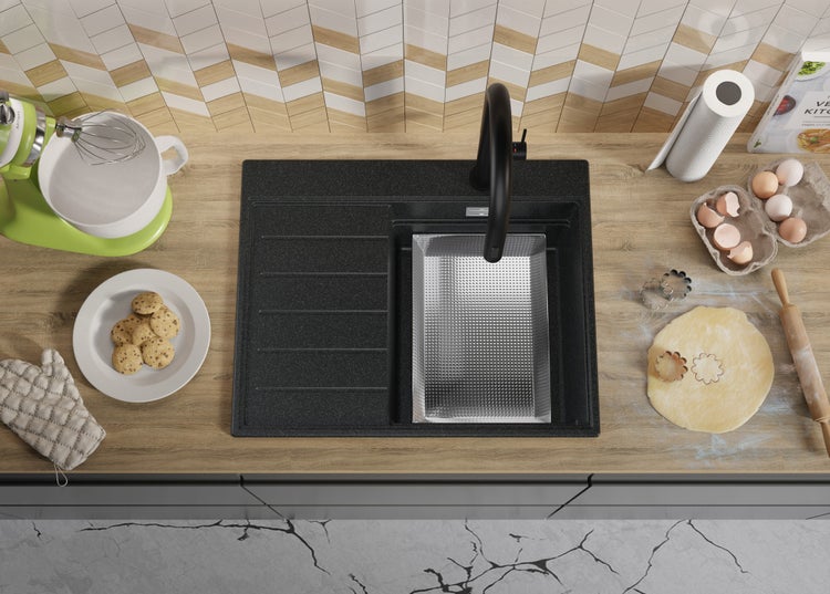 Küchenszene mit Spüle, Armatur und Backutensilien auf einer Arbeitsplatte.