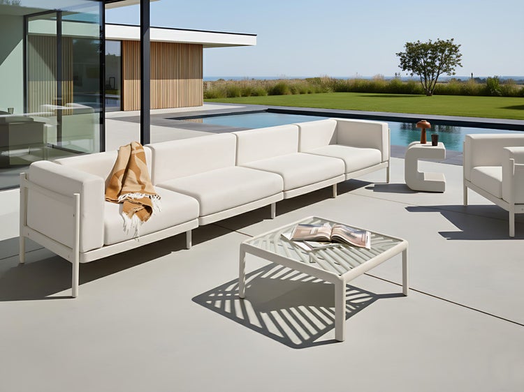 Outdoor-Szene mit modularem Sofa, Tisch und Dekoration auf einer Terrasse