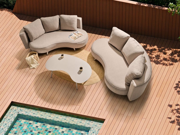 Terrasse mit Gartenmöbeln, bestehend aus zwei Sofas, einem Tisch und einem Korb