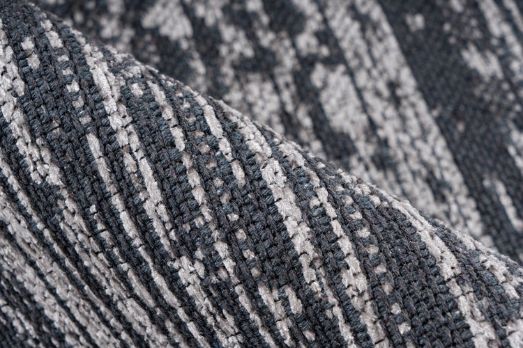 Nahaufnahme eines gewebten Teppichs mit strukturierter Oberfläche und linearem Muster.