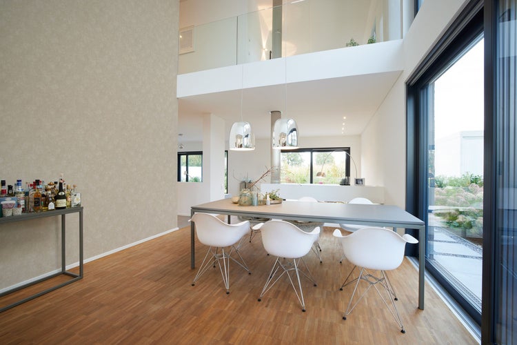 Heller Essbereich mit Esstisch, Stühlen und Parkettboden in einem modernen Haus.