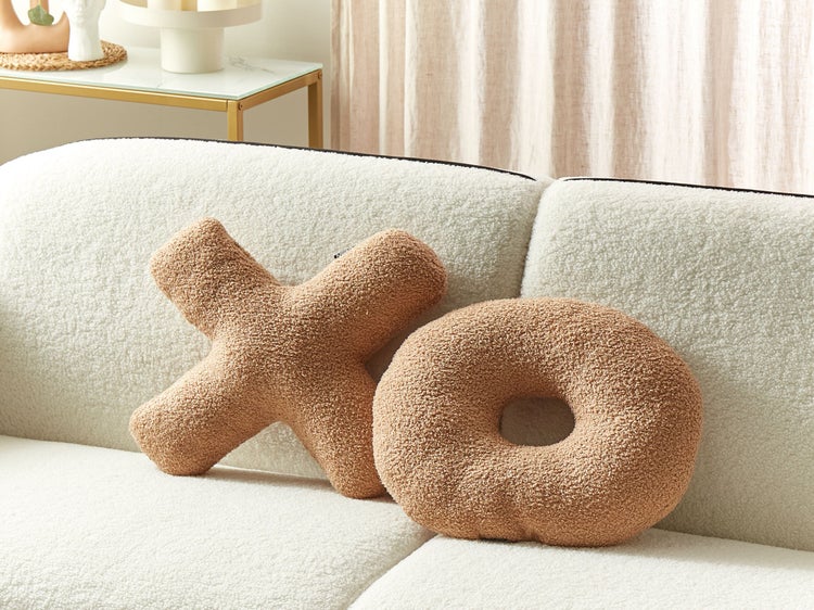 Dekorative Kissen in X- und O-Form auf einem Sofa