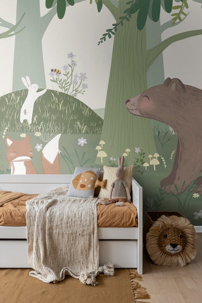 Kinderzimmer mit Waldtiermotivtapete, Bett und Spielzeugkorb