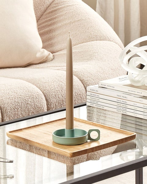 Kerzenständer mit Kerze auf einem Tisch mit Zeitschriften