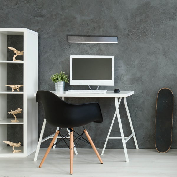 Arbeitszimmer mit Schreibtisch, Computer, Stuhl, Regal und Skateboard.