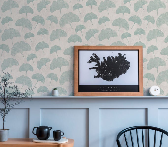 Helles Esszimmer mit Esstisch, Stühlen und Wandtapete mit Blättermuster