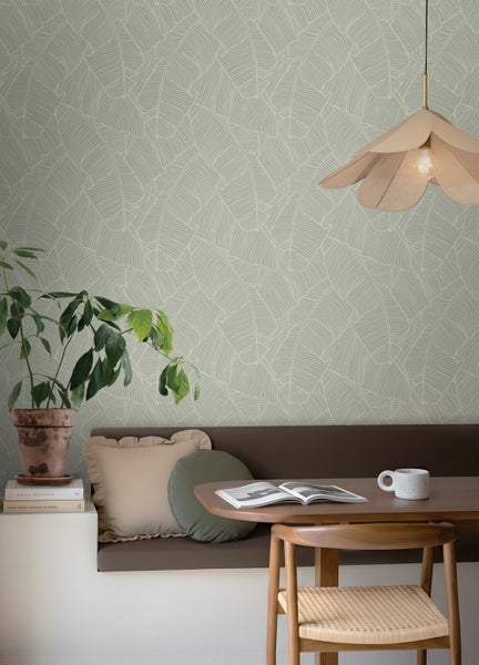 Wohnraum mit Blättertapete, Holztisch und Stuhl