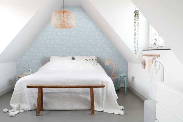 Schlafzimmer im Dachgeschoss mit Himmelbett, Rattanhängelampe und floraler Tapete