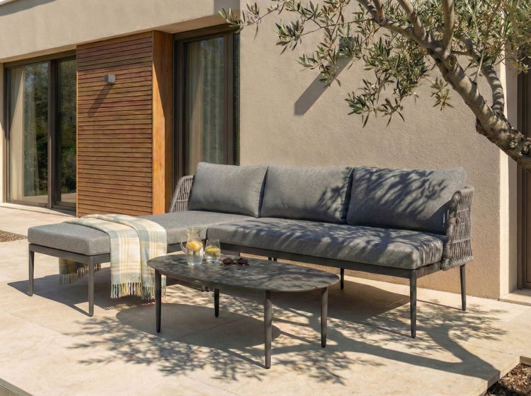 Graue Gartenlounge mit Tisch und Decke auf der Terrasse