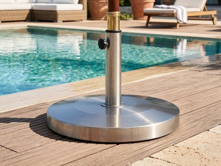Runder Sonnenschirmständer aus Edelstahl auf einer Holzterrasse am Pool.