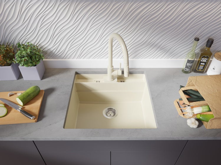 Küchenspüle aus Verbundwerkstoff mit Armatur und frischen Lebensmitteln auf der Arbeitsplatte