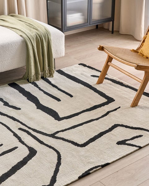 Dekorativer Teppich mit abstraktem Muster in einem hellen Wohnraum.