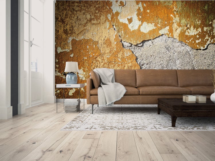 Fototapete in industriellem Design mit Beton- und abblätternder Putzoptik in einem hellen Wohnzimmer mit braunem Ledersofa und Holzboden.