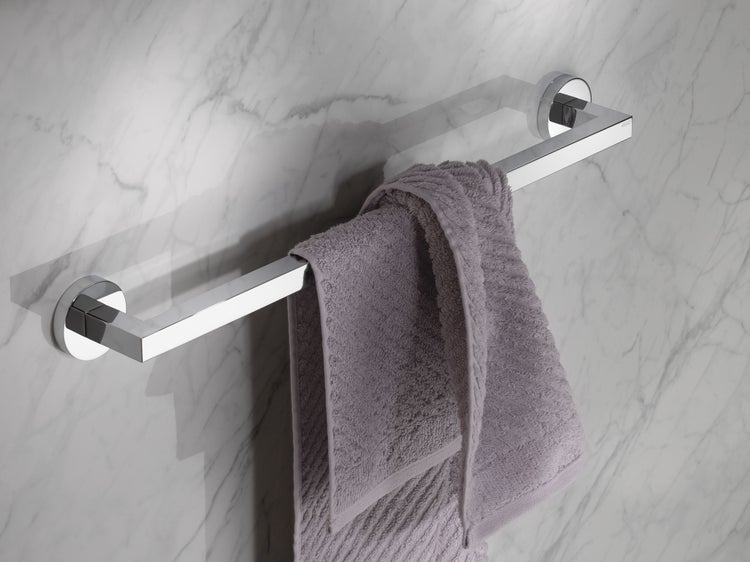 Ein moderner Handtuchhalter aus Metall zur Wandmontage mit einem hängenden Handtuch vor einer marmorierten Wand.