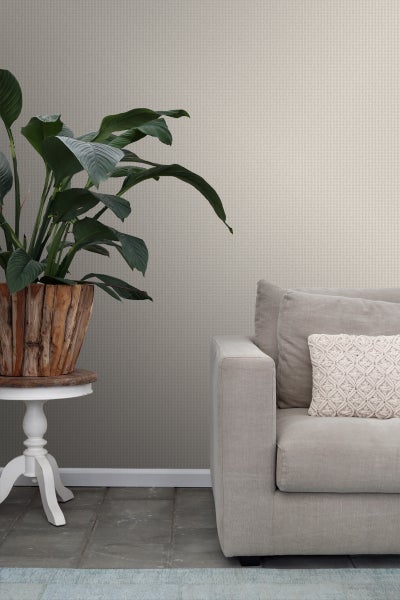 Nahaufnahme eines Raumes mit gemusterter Tapete, Sofa und Zimmerpflanze.