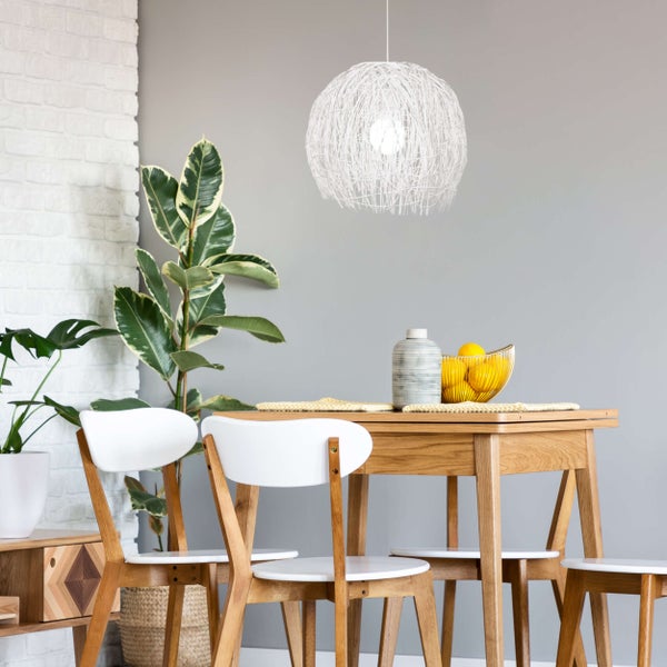 Esszimmer mit Holztisch, Stühlen, kugelförmiger Lampe und Zimmerpflanzen.