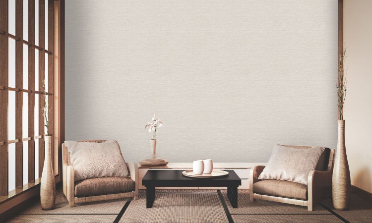 Szene mit einer mit Tapete verkleideten Wand, einer Bank mit Körben und einem Essbereich im Hintergrund