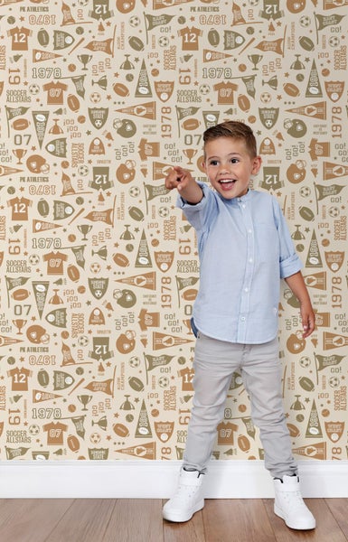 Ein Junge steht vor einer Wand mit einem Muster aus Sportmotiven