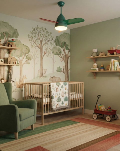 Kinderzimmer mit Gitterbett aus Holz, grünem Sessel, Wald-Wandbild, Deckenventilator mit Licht, Holzregalen und gestreiftem Teppich.