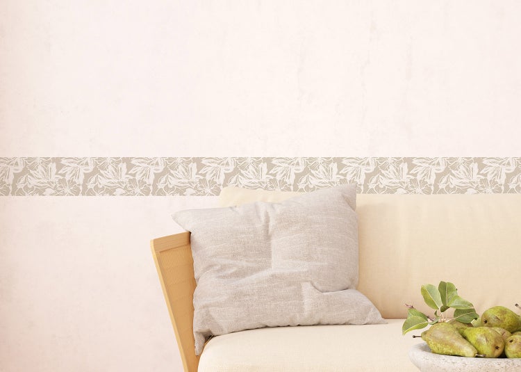 Tapetenbordüre mit floralem Muster in einem hellen Wohnzimmer mit Sofa, Couchtischen und Teppich.