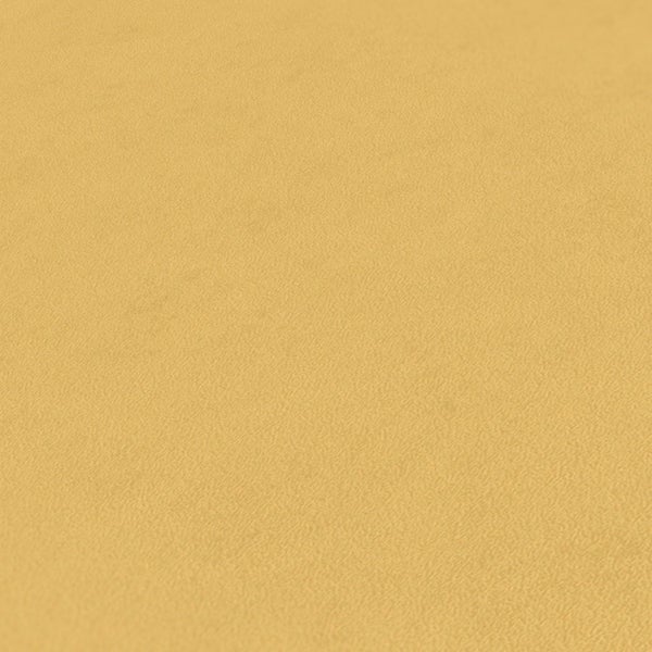 Wohnzimmer mit Sofa, Kissen, Bücherstapel und Lampe vor einer Wand