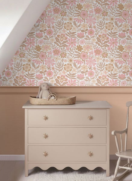 Kinderzimmer mit floral gemusterter Tapete, weißem Schreibtisch, einer Lampe, Spielzeug und einem Wandregal mit Dekoration.