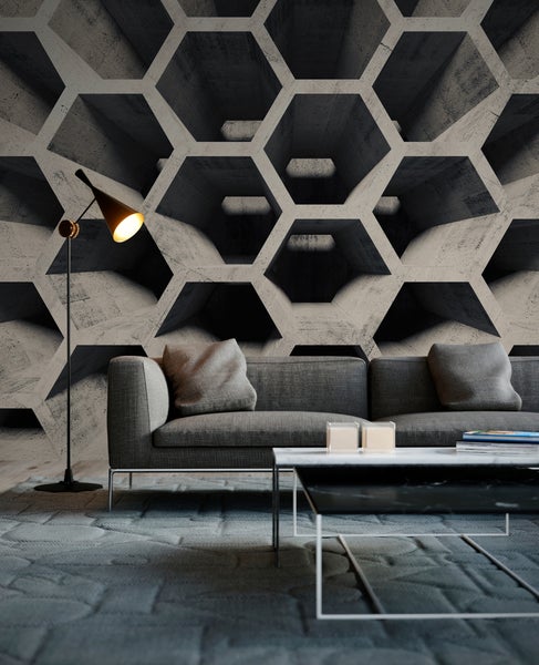 Moderne Wohnzimmereinrichtung mit einer dreidimensionalen Fototapete im grauen Beton-Wabenmuster, dazu ein graues Sofa, eine Stehlampe und Couchtisch.
