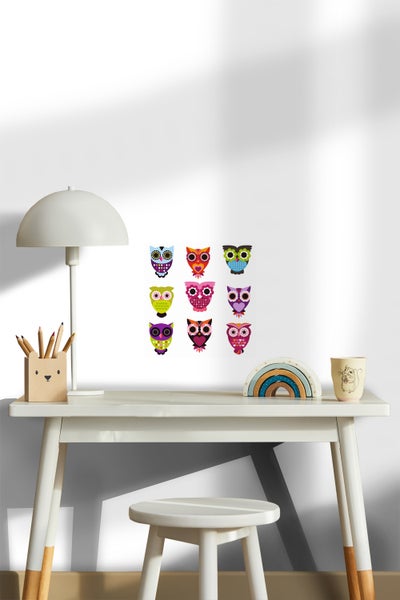 Dekoratives Kinderzimmer mit Schreibtisch, Stuhl und Wandtattoo mit Eulenmotiven.