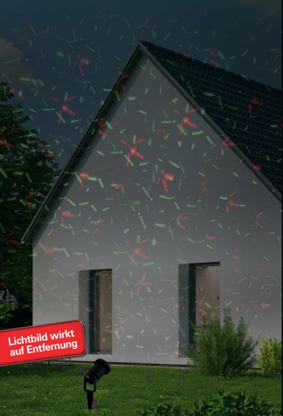 Hausfassade mit rotem und grünem Lichteffekt durch einen Gartenstrahler.