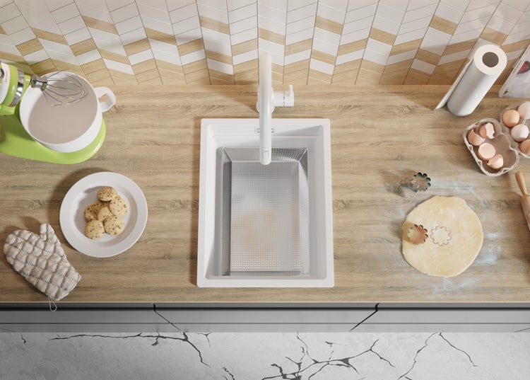 Küchenszene mit Spüle, Armatur, Küchenmaschine, Backzutaten und Keksen