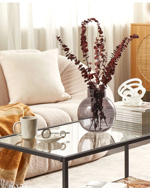 Wohnzimmer mit Couch, Glascouchtisch, Deko-Vase und Wohnaccessoires