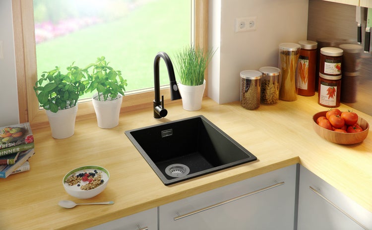 Küchenszene mit Spüle, Armatur, Lebensmitteln und Pflanzen