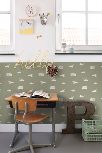 Kinderzimmer mit Tapete mit Fahrzeugmuster, Schreibtisch und Hockern.