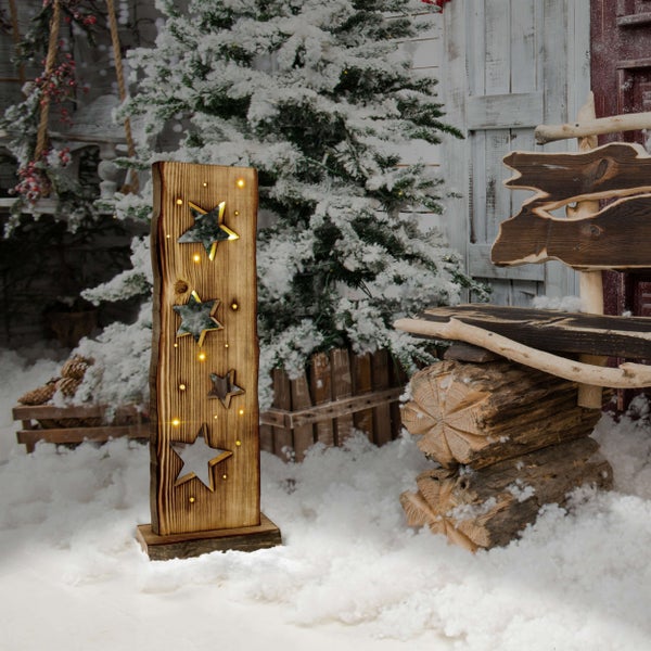 Dekorative Holzleuchte mit Sternenmuster vor weihnachtlichem Hintergrund