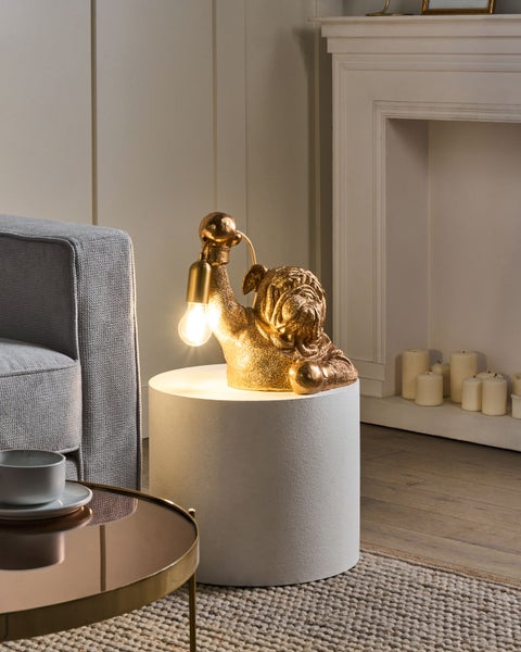 Dekorative Bulldoggenlampe auf einem Beistelltisch in einem Wohnzimmer.