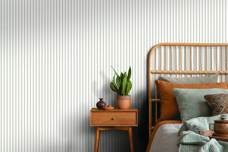 Schlafzimmer mit gestreifter Tapete, Rattanhaupt und Nachttisch