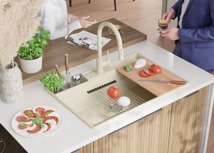 Spüle mit Armatur, Schneidebrett, Tomaten und Mozzarella in einer hellen Küche.