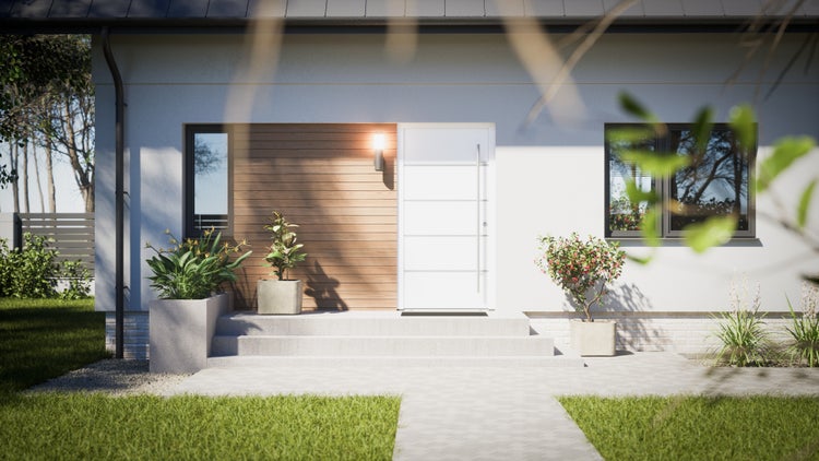 Fassade eines Hauses mit Eingangstür, Fenster und Bepflanzung