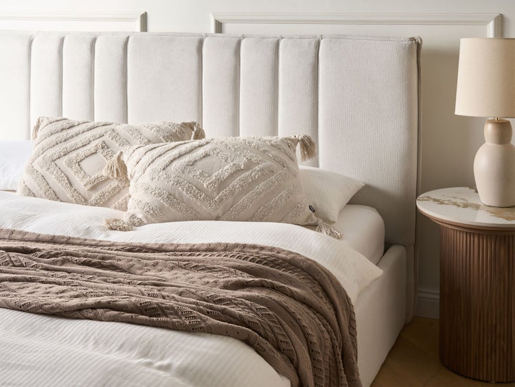 Zwei dekorative Kissen mit geometrischem Muster und Quasten