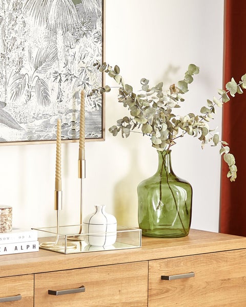 Dekoratives Stillleben mit Kerzenleuchtern, Vase und botanischem Druck auf einer Kommode