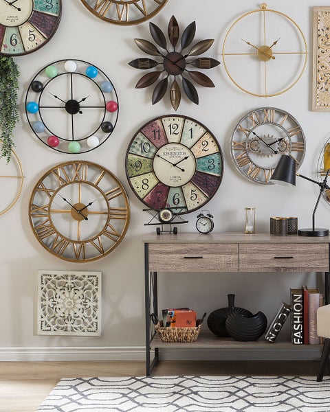 Wanddekoration mit verschiedenen Wanduhren und Konsolentisch
