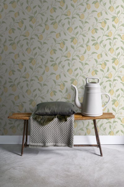 Dekorative Szene mit Zitronen Tapete, Holzbank, Kissen und Gießkanne.