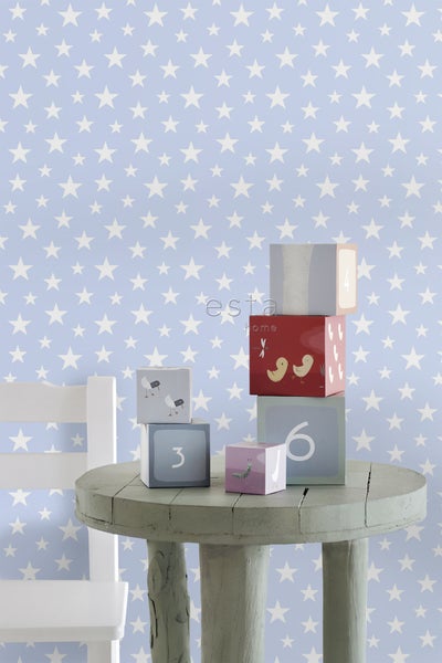 Dekorative Holzklötze auf einem Tisch mit Sternentapete