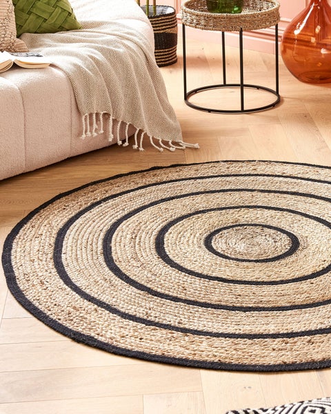 Runder Teppich aus Jute mit konzentrischen Kreisen im Wohnzimmer.
