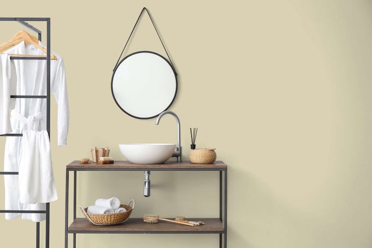 Helles, organisiertes Badezimmer mit minimalistischem Waschtisch aus Metall und Holz, Aufsatzwaschbecken, rundem Spiegel und Handtuchhalter.